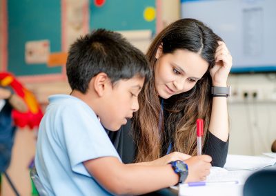 A teacher engaged in working with a pupil in the class